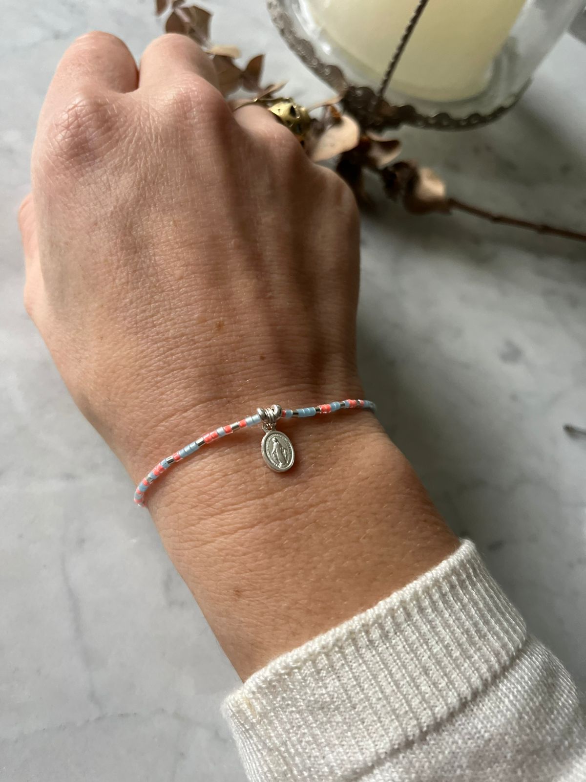 Pulsera de hilo cristales celeste rosados, con virgen de los rayos y detalles de plata, ajustable de 15cm a 20cm