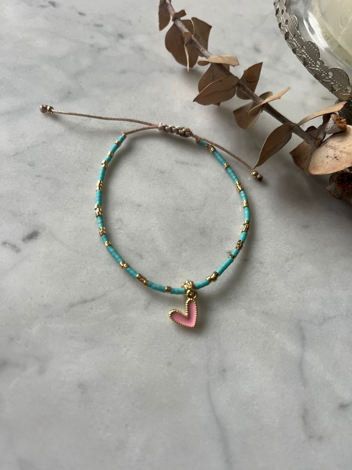 Pulsera con cristales celestes y detalles baño de oro con corazón rosado