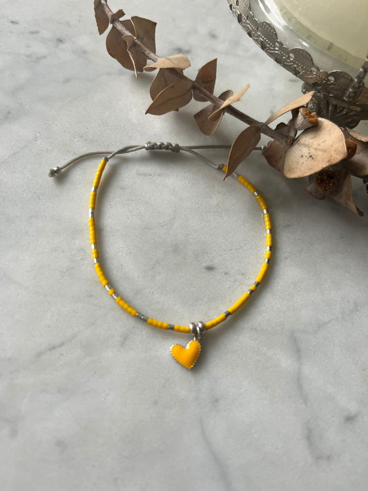 Pulsera hilo gris cristales y corazón amarillo detalles en plata