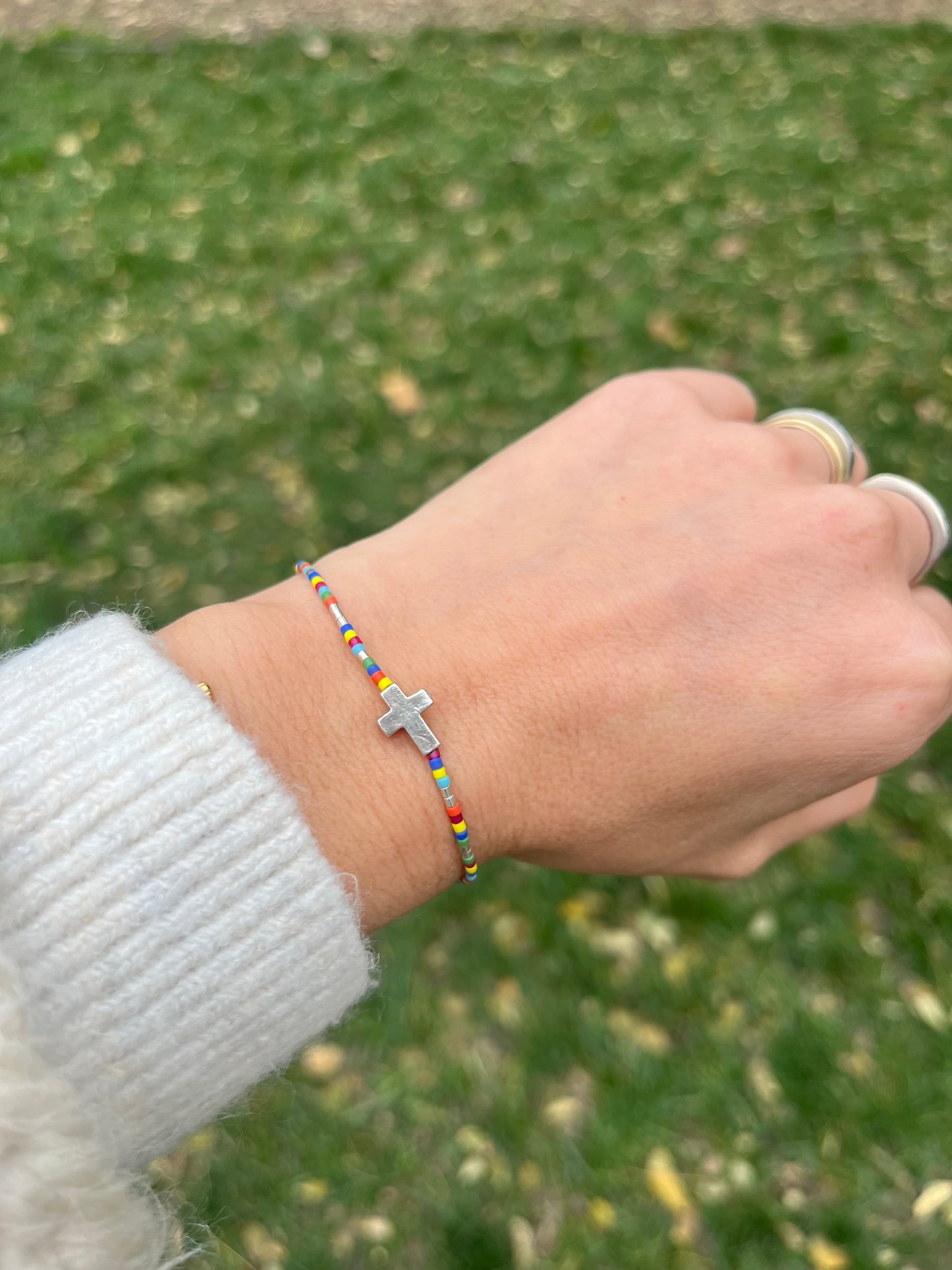 Pulsera de hilo gris con mostacillas de colores , detalles y cruz de plata, ajustable de 15cm a 20cm