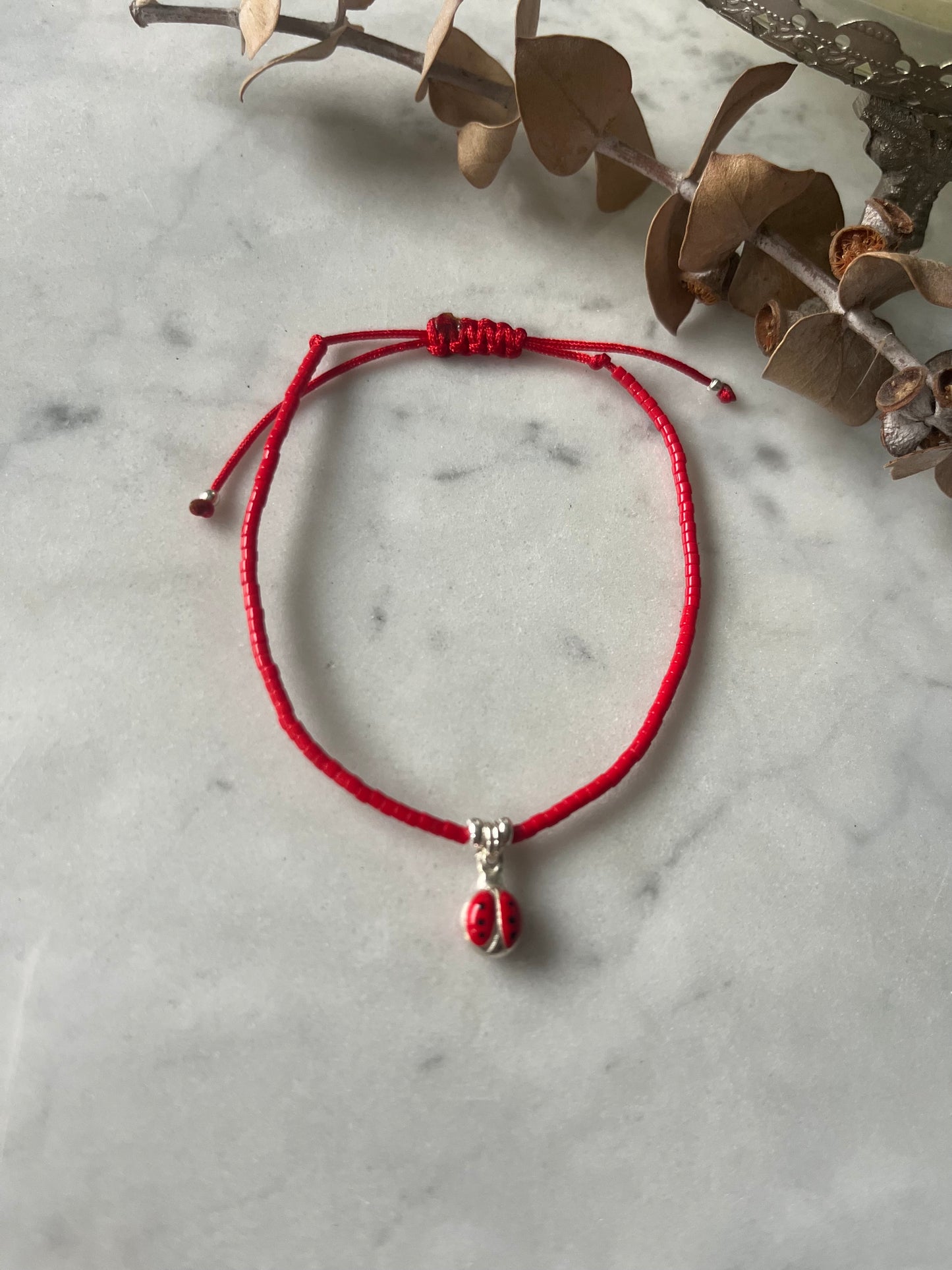 Pulsera hilo rojo con cristales rojos y chinita de plata