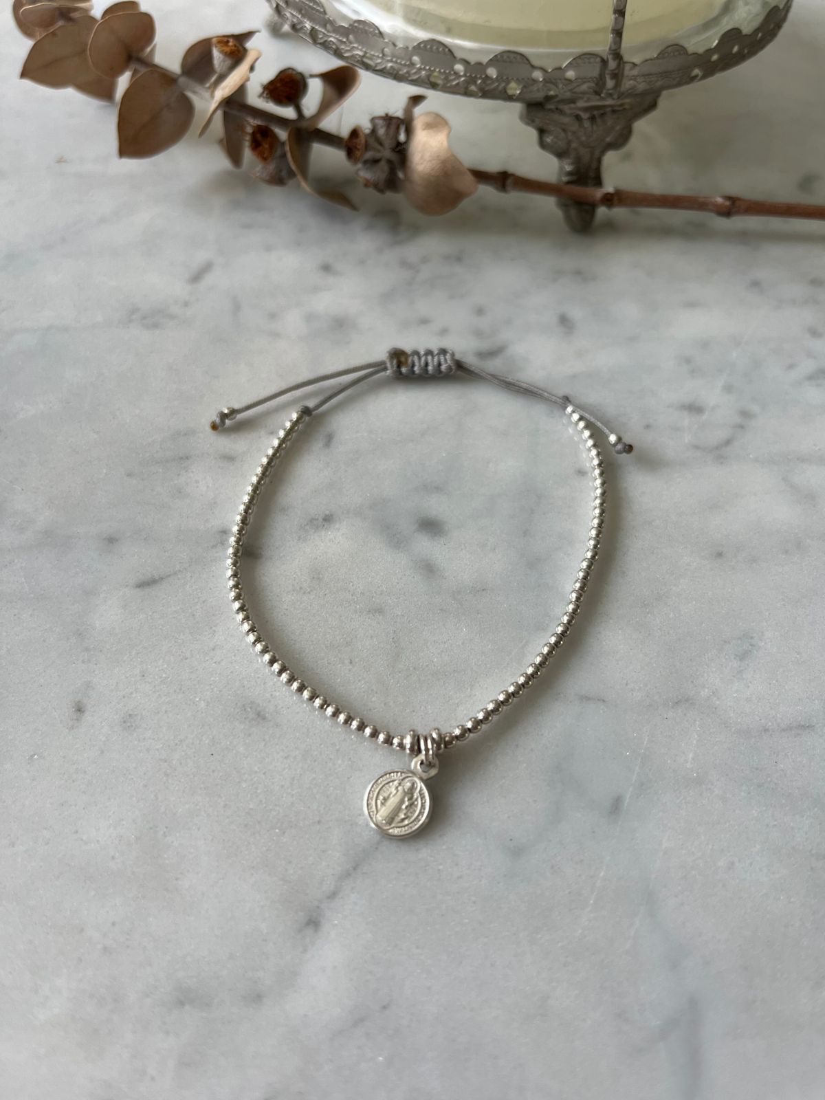 Pulsera hilo gris, mostacillas de plata, y San Benito en plata ajustable de 15 a 20cm