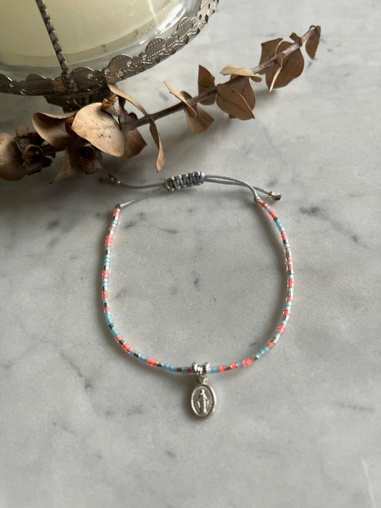 Pulsera de hilo cristales celeste rosados, con virgen de los rayos y detalles de plata, ajustable de 15cm a 20cm