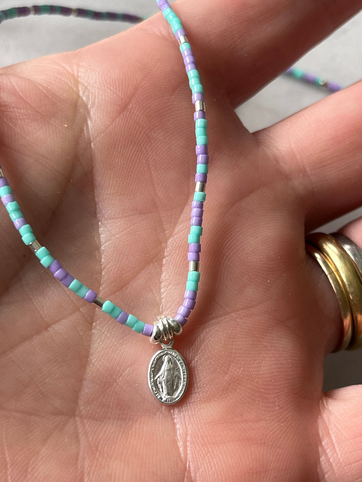 Collar cristales celeste y morados con Virgen de los Rayos
