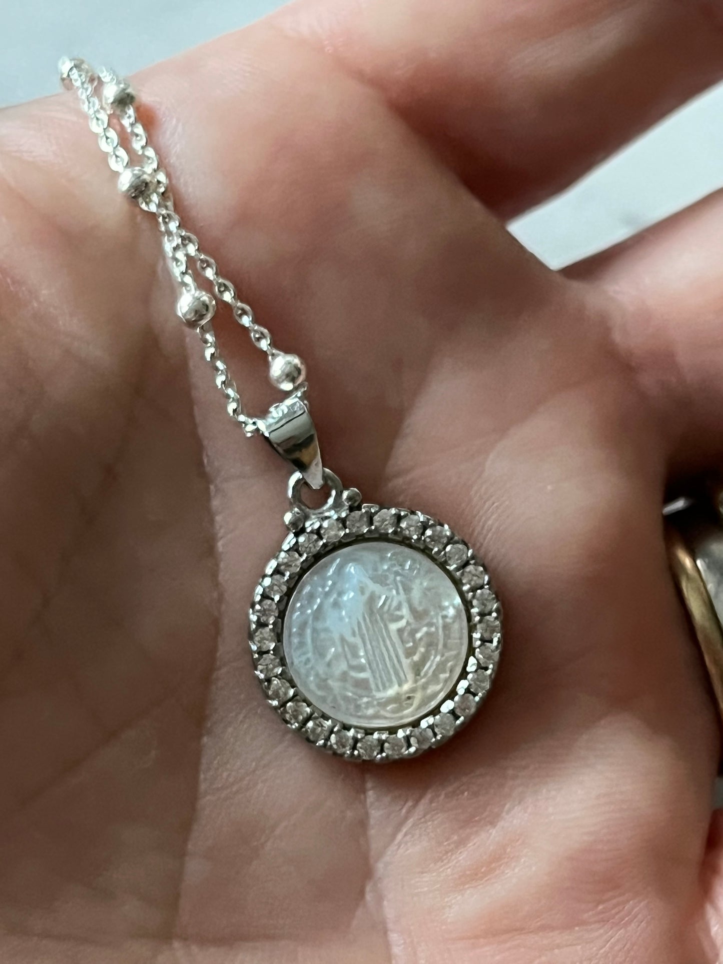 ✨ Dije San Benito en nácar y circones