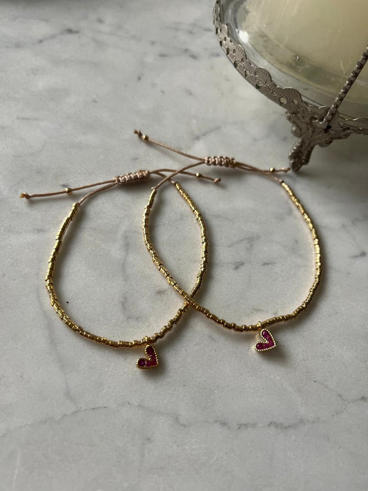 Pulsera de hilo con mostacillas bañadas en oro de 24k con corazon fucsia