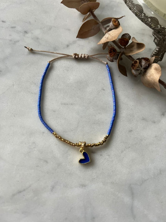 Pulsera con cristales azules mate, y mostacillas bañadas en oro con corazon azul