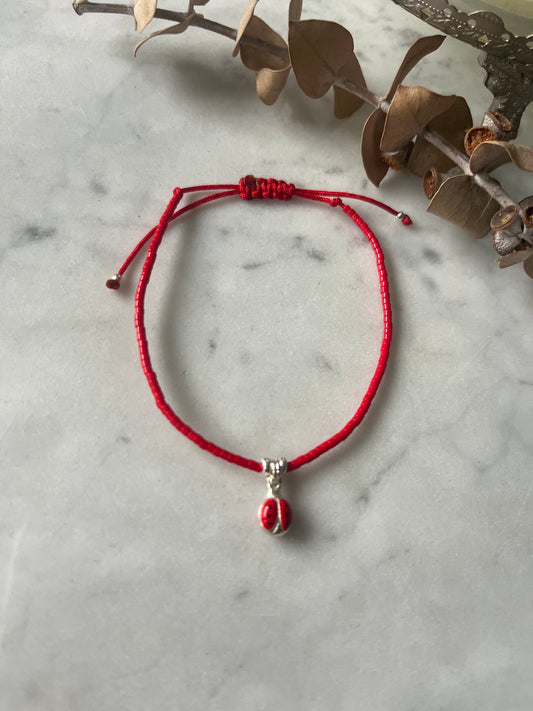 Pulsera hilo rojo con cristales rojos y  chinita de plata