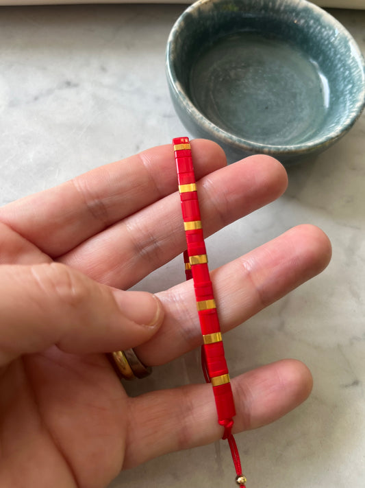 Pulsera hilo rojo cristales rojos y detalles en baño de oro, ajustable de 15cm a 20cm