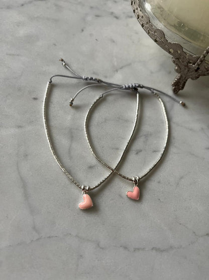Pulsera de hilo gris con mostacillas de plata y corazón de plata rosado