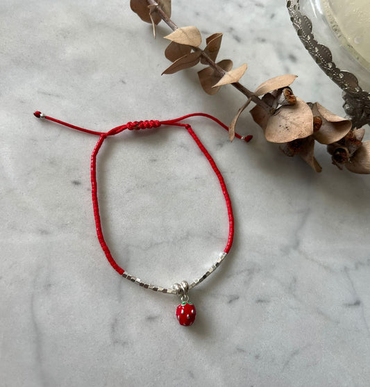 Pulsera de hilo rojo, con frutilla y detalles de plata