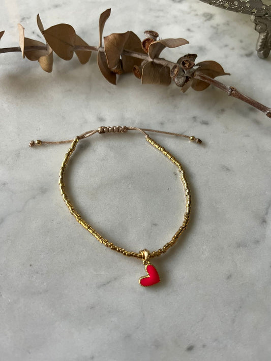 Pulsera de hilo con mostacillas bañadas en oro de 24k con corazon flúor rosado